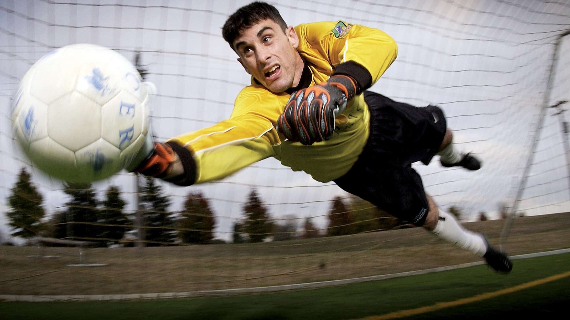 football goal keeper leaping for the ball